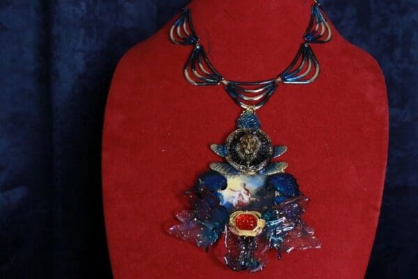 A red and blue necklace with a lion on it