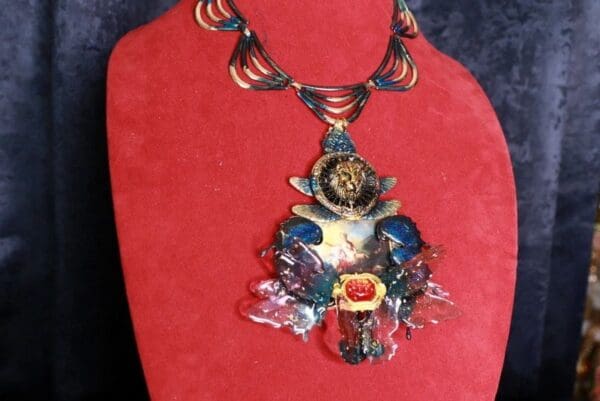 A red display with a necklace and a painting