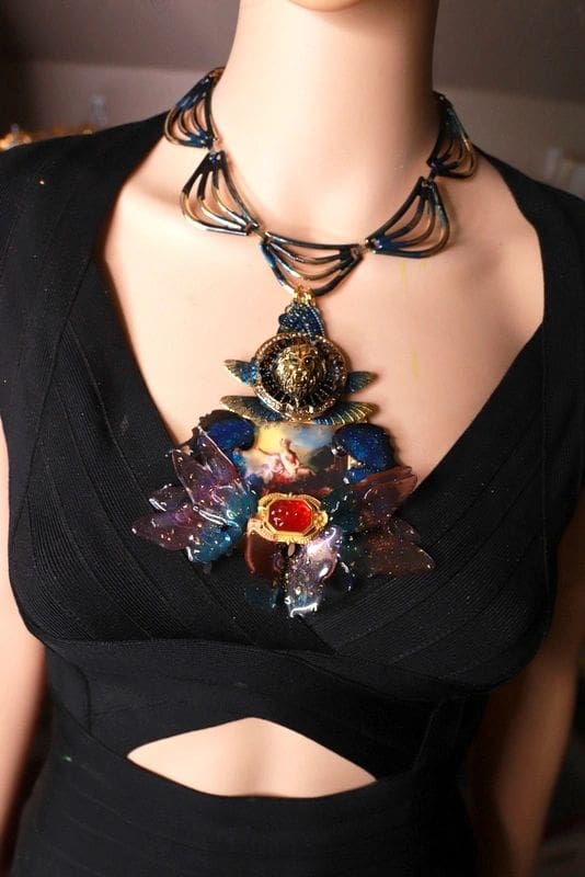 A woman wearing a black dress and a necklace.