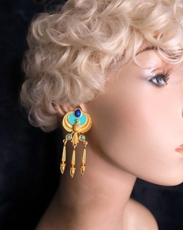 A woman with blonde hair wearing gold earrings.