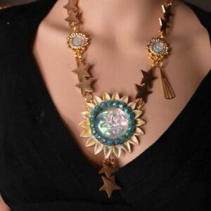 A woman wearing a necklace with stars and a sun.