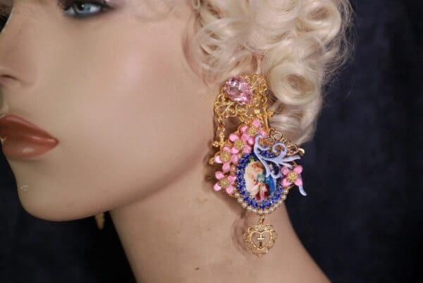 A woman with blonde hair wearing pink and blue earrings.