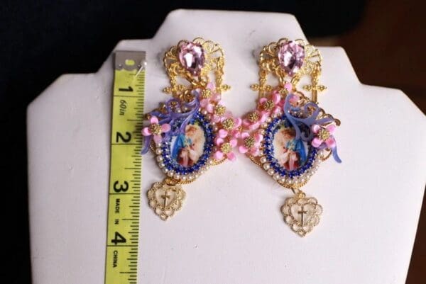 A pair of earrings with a picture and beads on them.