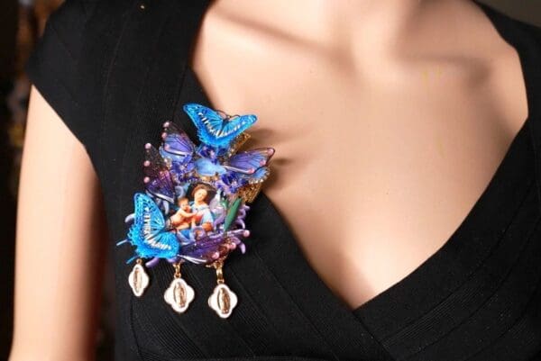 A woman wearing a blue butterfly brooch with shells.