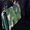 A close up of the strap on a green purse