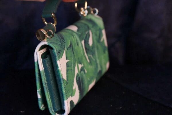 A close up of the strap on a green purse