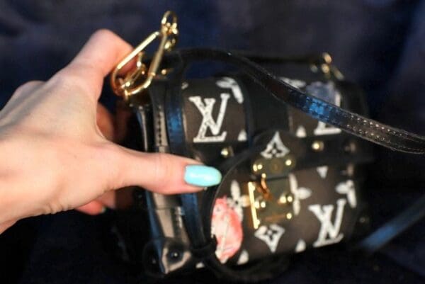 A person holding onto a black and white purse