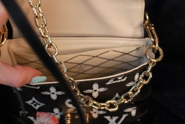 A close up of the chain on a purse
