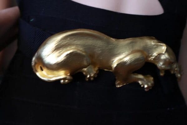 A gold colored animal sitting on top of a black table.
