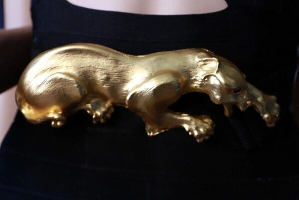 A gold bear statue sitting on top of a table.