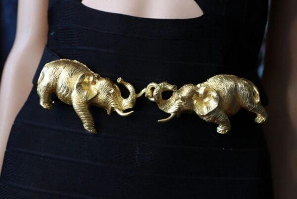 Two gold elephants are facing each other.