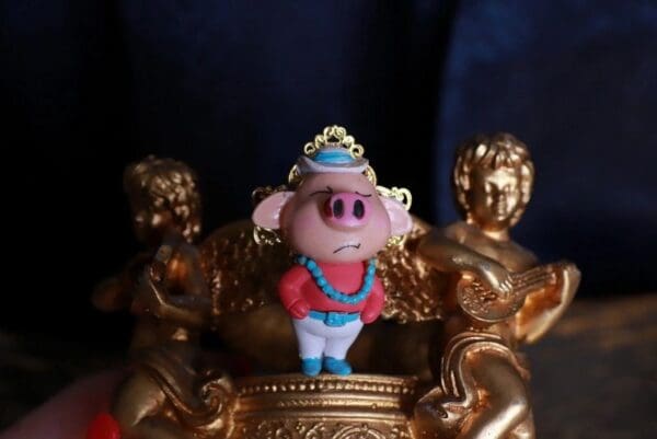 A close up of a figurine on top of a gold statue