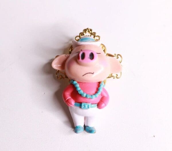A pink and white pig with a crown on it's head.