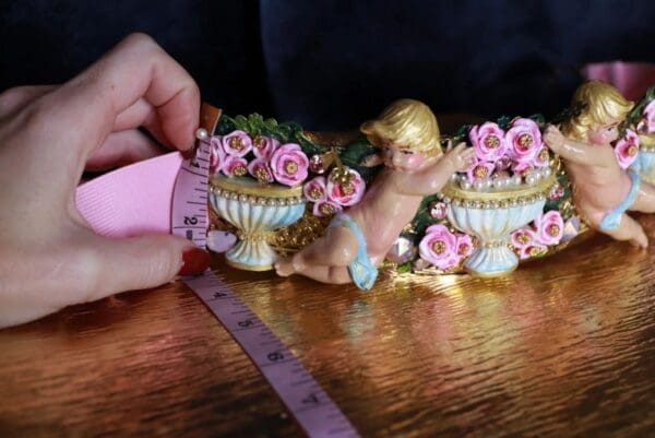A person measuring the length of a doll 's head.