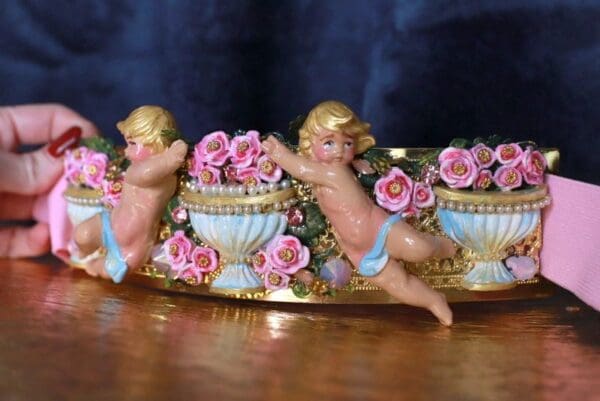 A couple of cherubs sitting on top of a bowl.