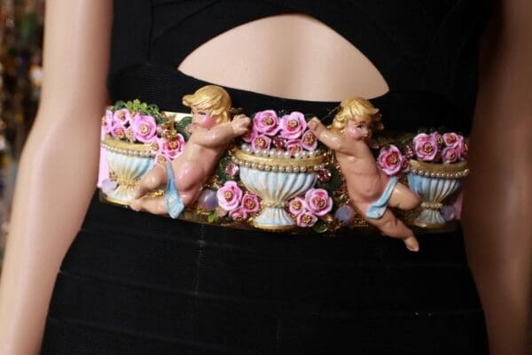 A woman wearing an apron with three cherubs on it.