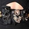 A woman 's black dress with many different jewelry.
