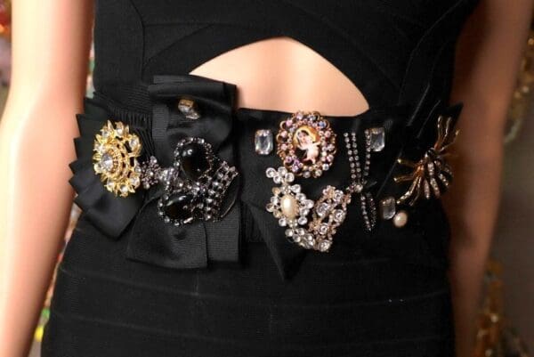 A woman wearing black and gold jewelry on her dress.