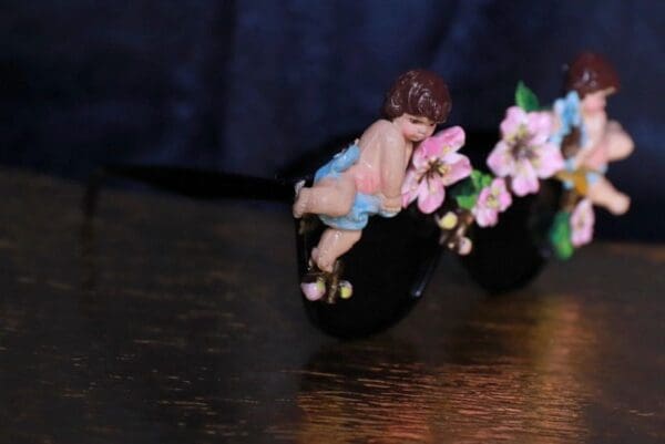 A small figurine of a baby sitting on top of a pair of shoes.