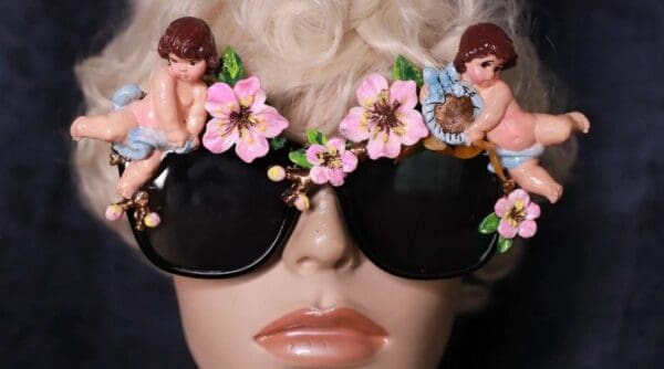 A mannequin wearing sunglasses with flowers and angels on them.
