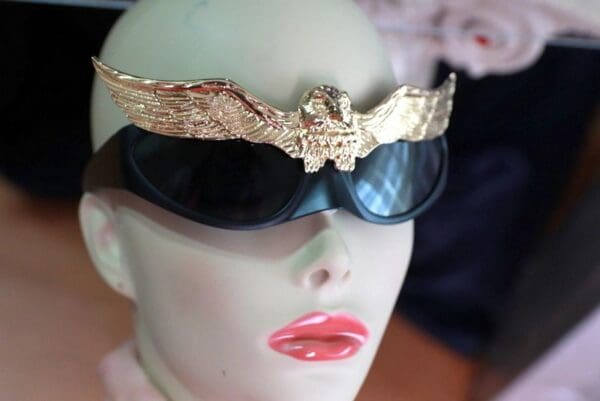 A mannequin wearing sunglasses and a gold crown.