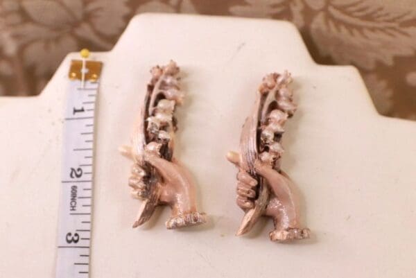 A pair of earrings sitting on top of a white counter.