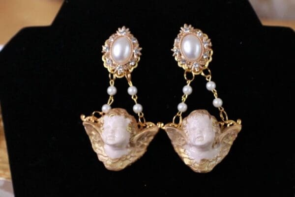 A pair of earrings with pearls and gold