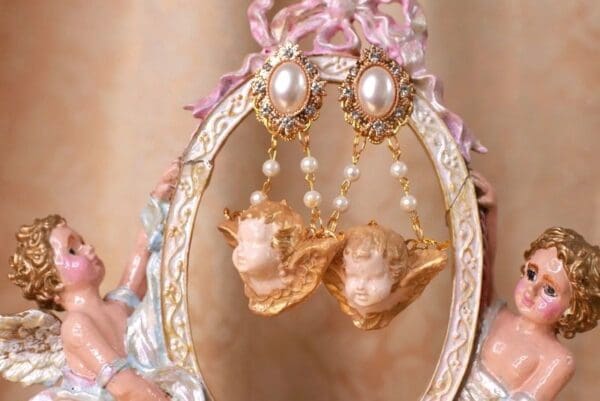 A pair of earrings hanging from the side of a mirror.