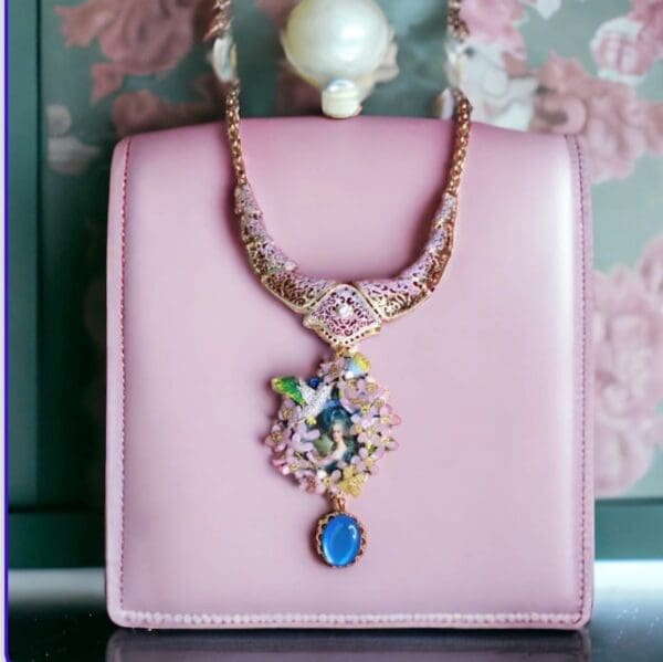 A pink purse with a blue and white necklace on it