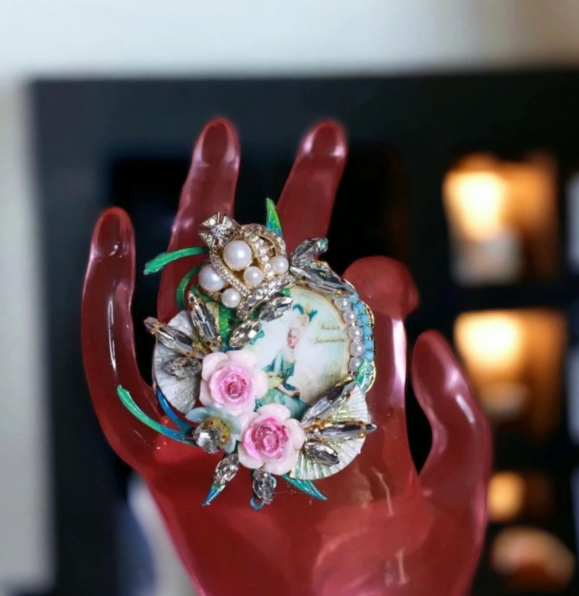 A red hand holding a shell with flowers on it.