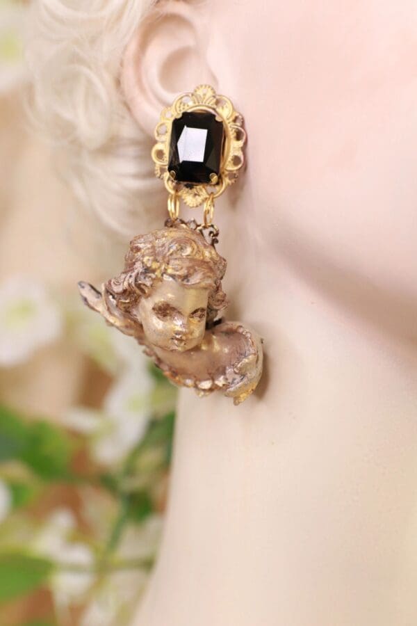 A woman wearing earrings with an image of a head.