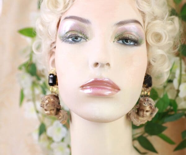 A mannequin with long blonde hair and black earrings.