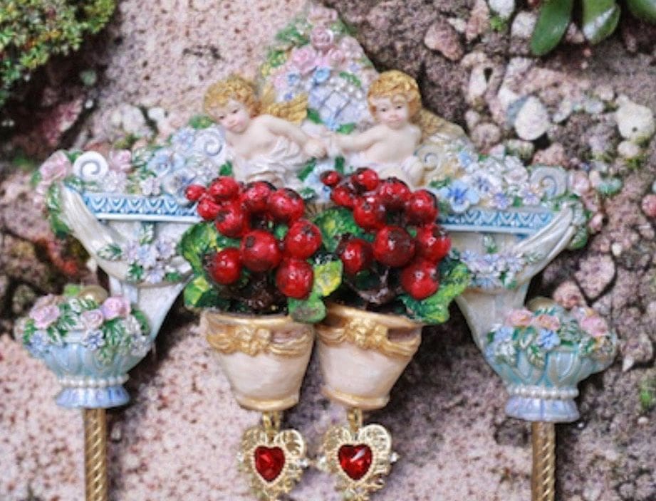 A pair of red flowers in vases on top of a wall.