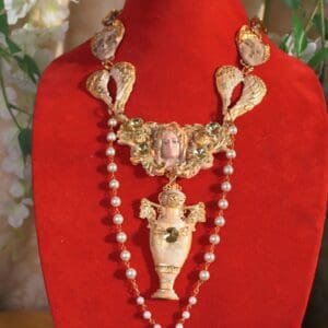 A red velvet display with a necklace and a vase.