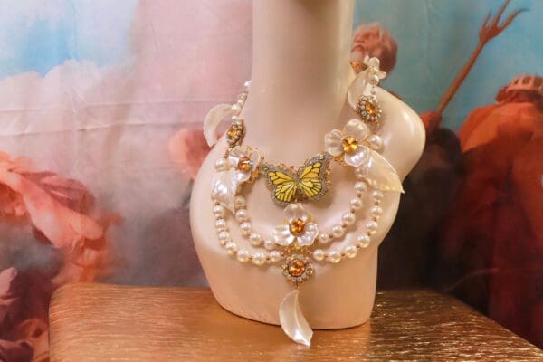 A necklace with pearls and butterflies on it