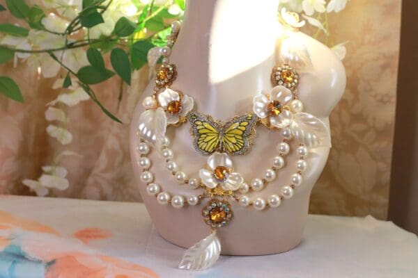A butterfly necklace with pearls and gold beads