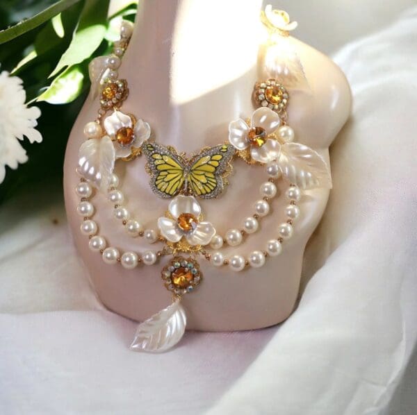 A butterfly and pearl necklace on a white shoe.