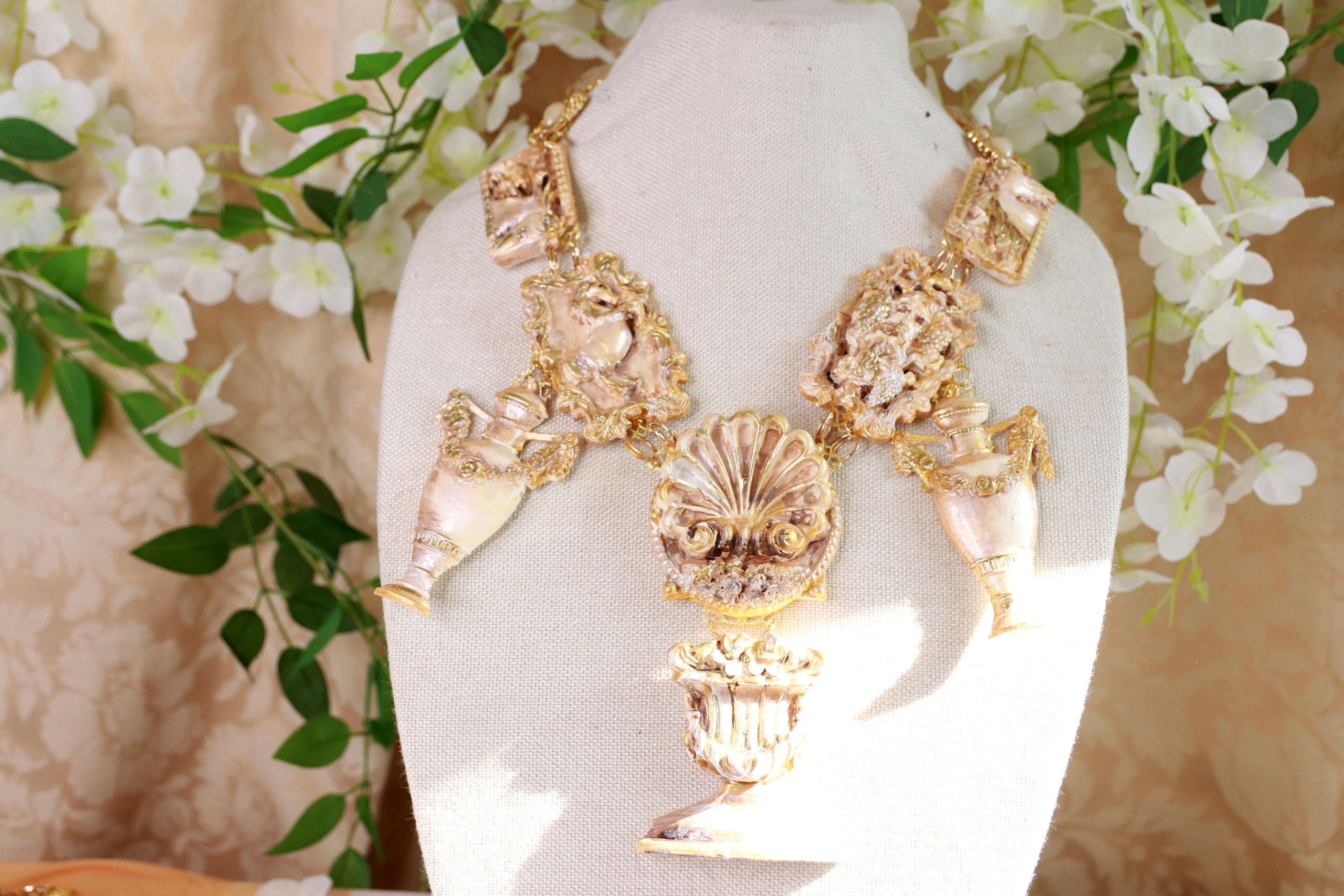 A necklace is displayed on a white stand.