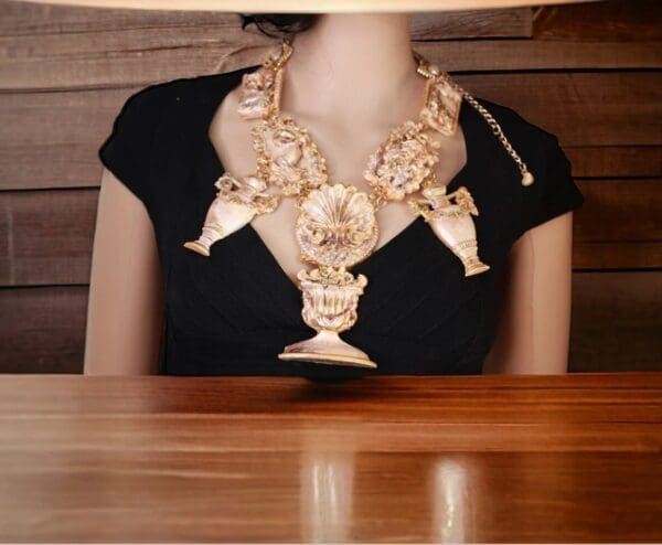 A woman sitting at a table wearing a necklace.