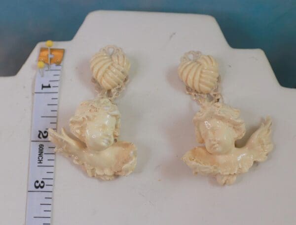 A pair of earrings sitting on top of a white board.