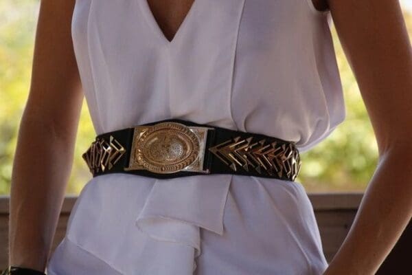 A woman wearing a white dress and belt.