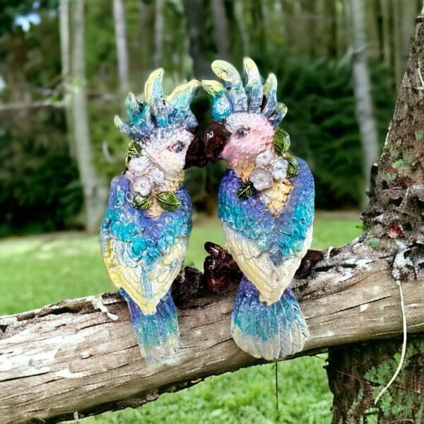 Two colorful birds are sitting on a tree branch.