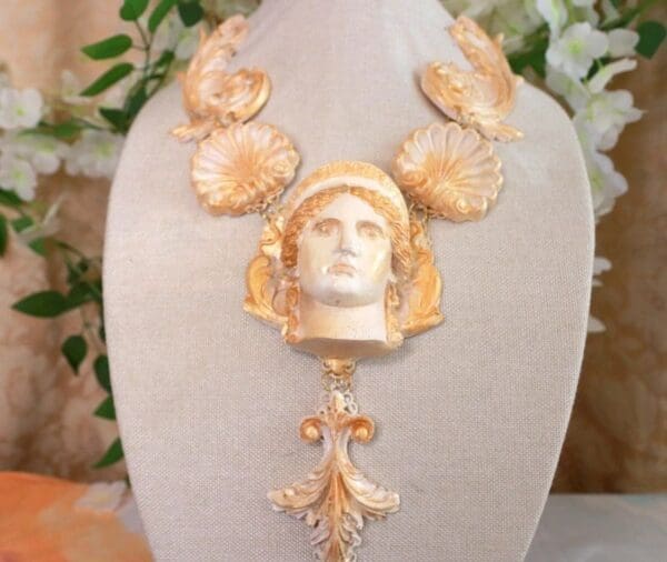 A gold necklace with a face on it