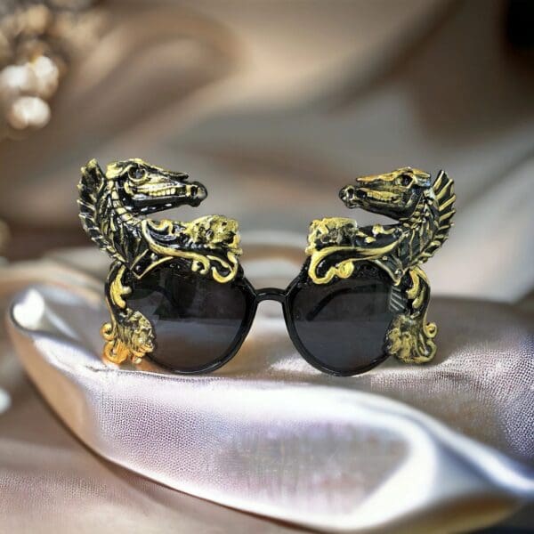 A pair of sunglasses with dragon heads on them.