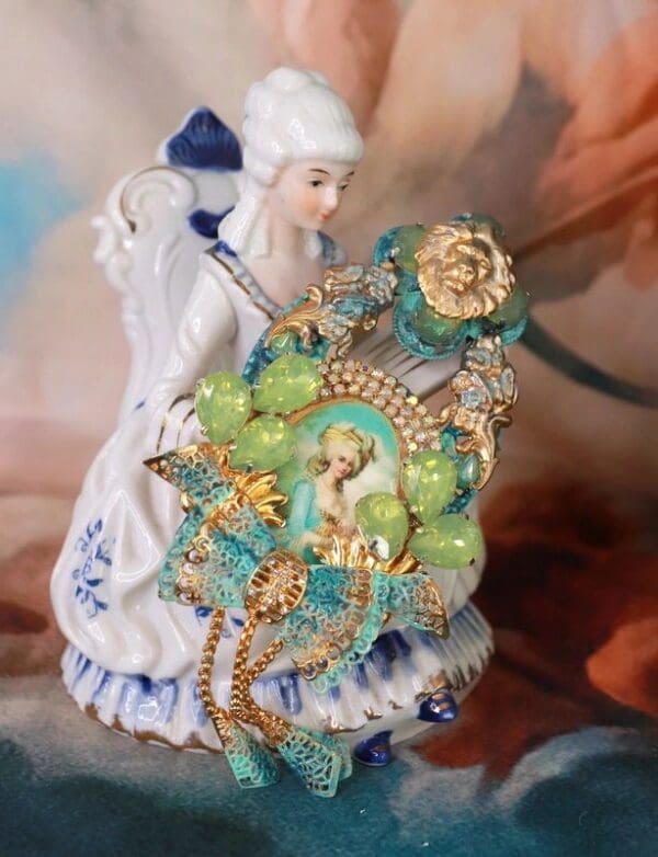 A statue of an angel holding a green and yellow rosary.