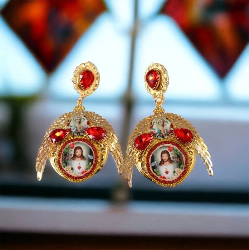 A pair of earrings with red stones and gold frames.