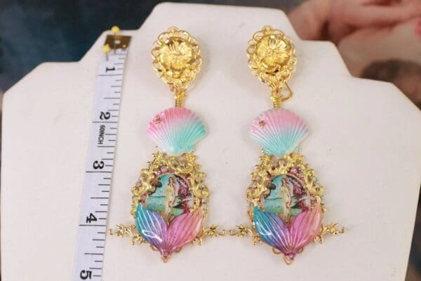A pair of earrings with gold and pink