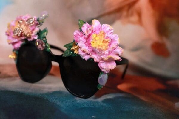 A pair of sunglasses with flowers on top.