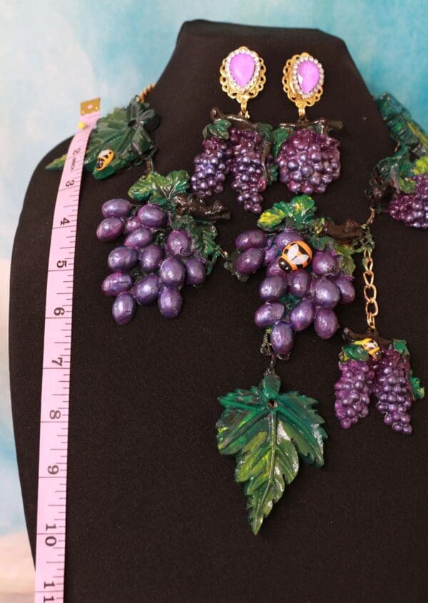 A necklace and earrings set of purple grapes.