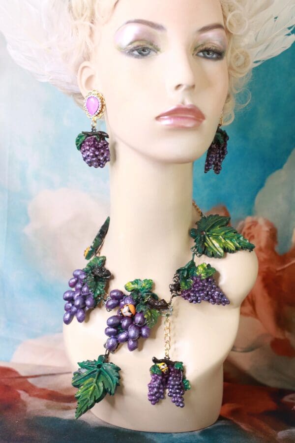 A woman wearing a necklace and earrings with grapes.